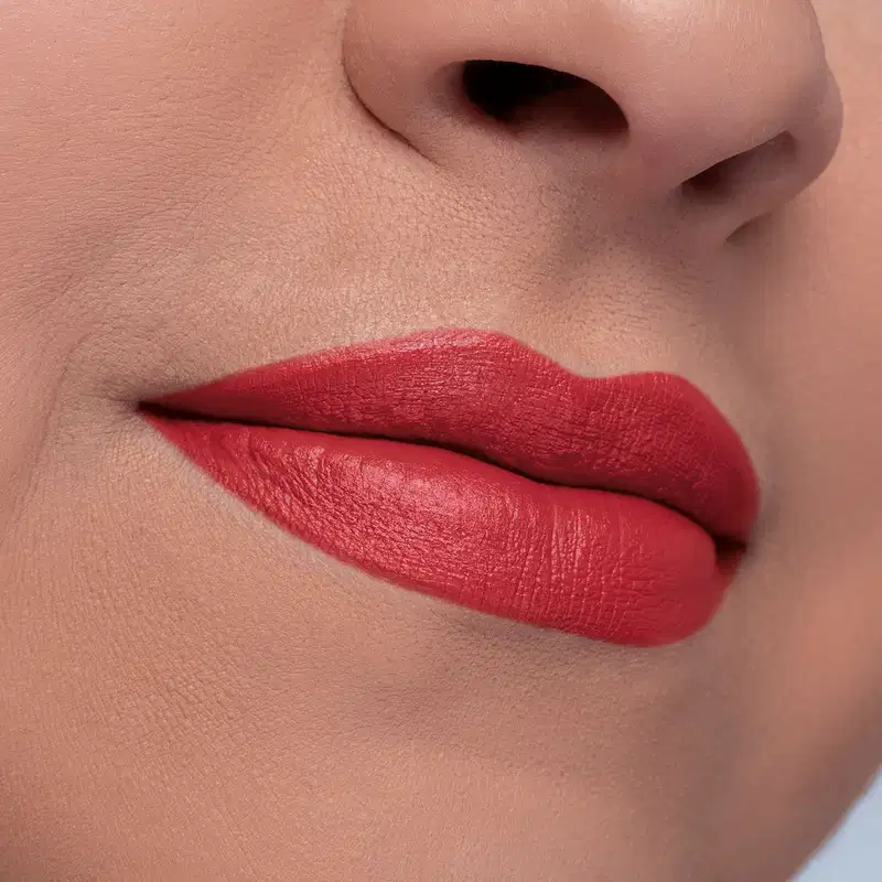 Close-up de um rosto feminino dando destaque para os lábios que usam o batom cremoso vermelho Intense by Amor.