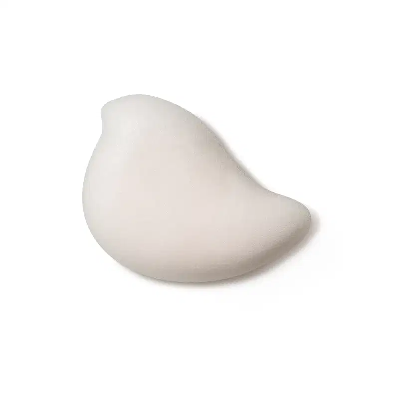 Textura branca, macia e cremosa da espuma de banho corporal Nuvem de Ideias Dr. Botica em superfície lisa e brilhante, posicionado sobre fundo branco.