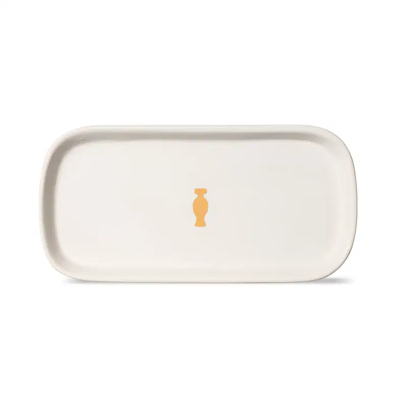 Bandeja para lavabo branca da marca Casa 214 no formato retangular com cantos arredondados e com logo do Boticário em dourado no centro.