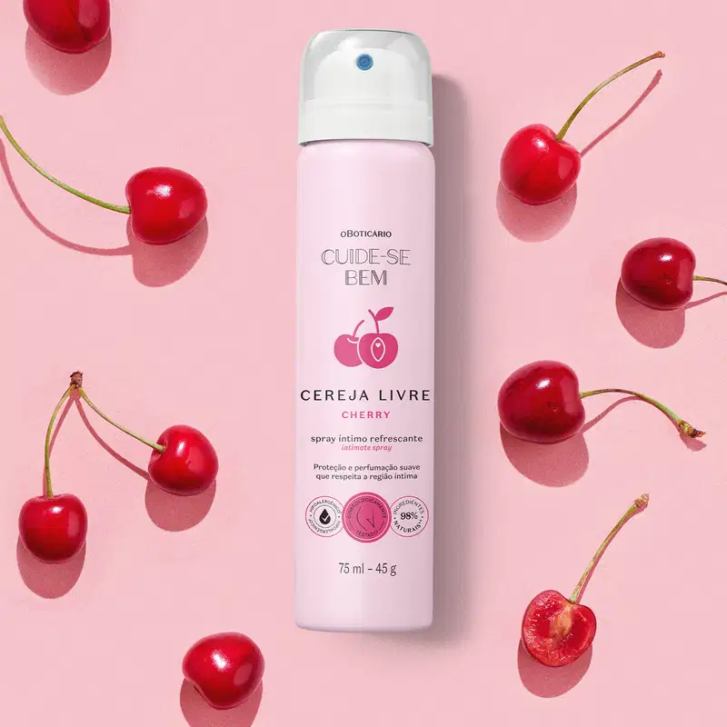Frasco rosa claro com tampa branca, letras pretas e cerejas vermelhas ilustradas no rótulo contendo 75ml de spray íntimo refrescante Cuide-se Bem Cereja Livre em fundo rosa com diversas cerejas vermelhas frescas espalhadas ao redor.