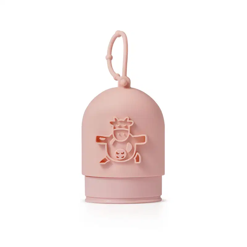 Capinha de silicone rosa para creme de mãos da marca Cuide-se Bem Deleite, com ilustração de uma vaquinha em relevo e alça para pendurar.
