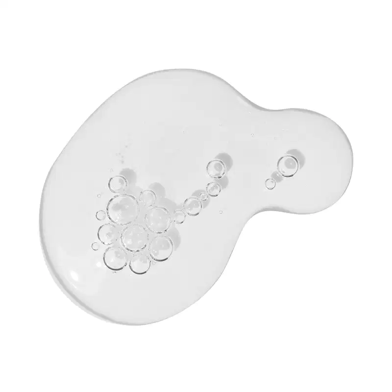 A imagem mostra algumas gotas do gel de limpeza antioleosidade Malbec Facial derramadas sobre uma superfície. É possível ver uma textura aquosa transparente, com pequenas bolhas de ar.