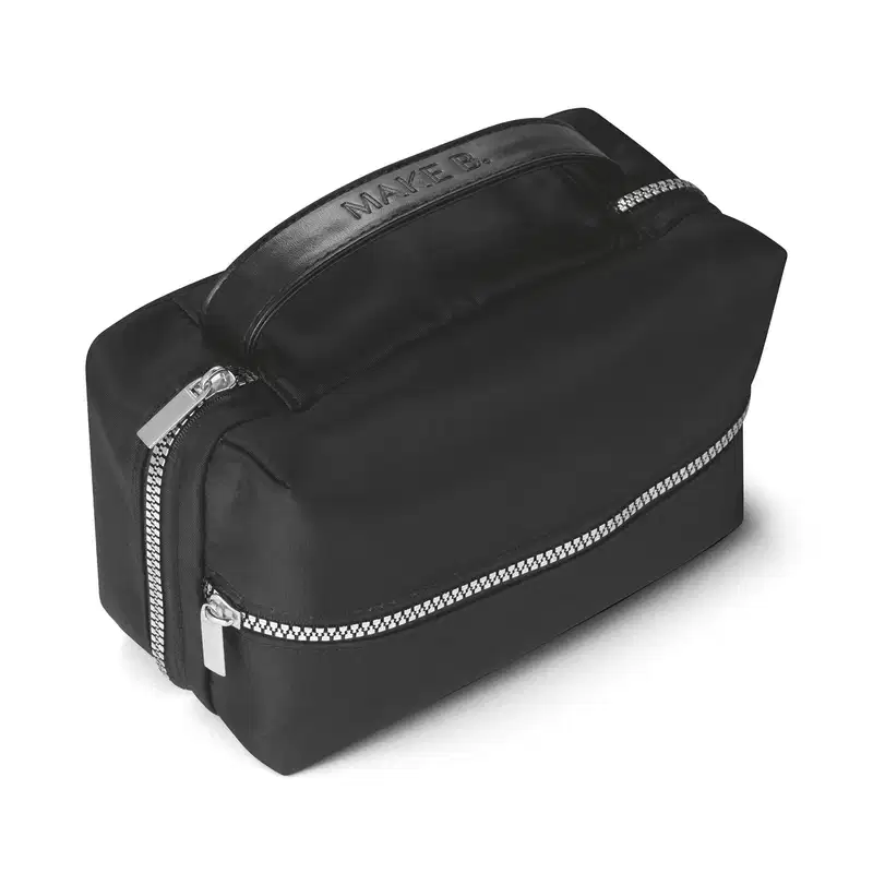 Nécessaire preta em formato retangular com alça superior. A parte frontal e a parte superior tem um zíper metálico prateado e o material é de nylon resistente. A alça possui o nome da marca Make B. gravado.