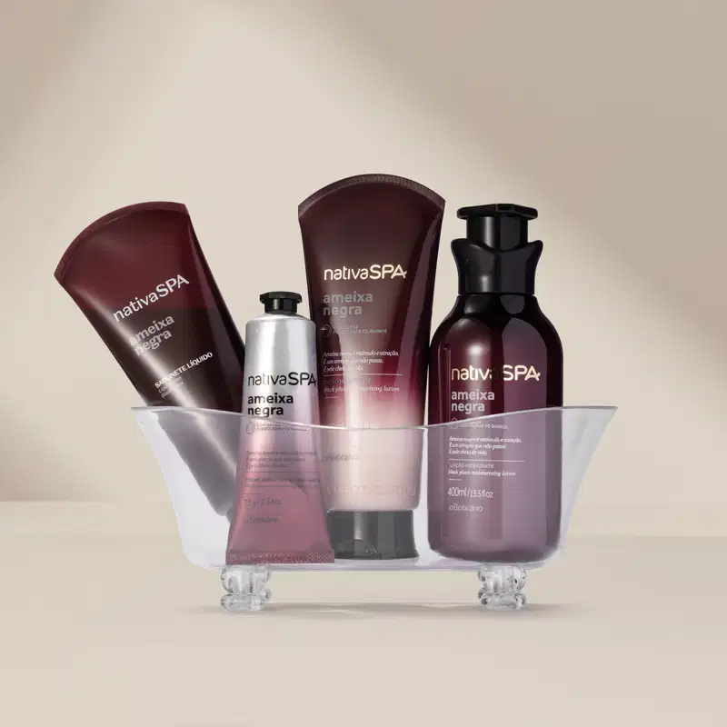 Produtos da marca Nativa SPA em embalagens roxas e pretas, dispostos sobre uma banheira de acrílico transparente, em um ambiente claro e neutro.