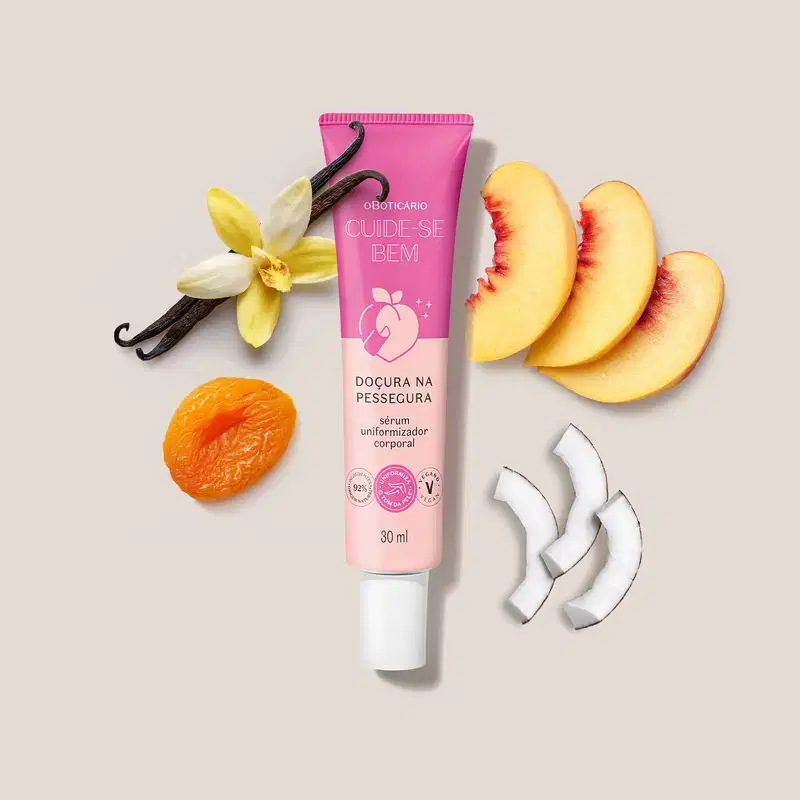 O produto apresentado é um sérum uniformizador corporal da linha Cuide-se Bem da marca O Boticário. Ao redor do tubo, há alguns ingredientes naturais, como uma flor de baunilha e fatias de pêssego, sugerindo a composição do produto.