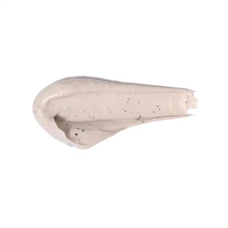 Textura cremosa, brilhante e densa de um item de cuidados com a pele, com pequenos pontos escuros visíveis em sua superfície.