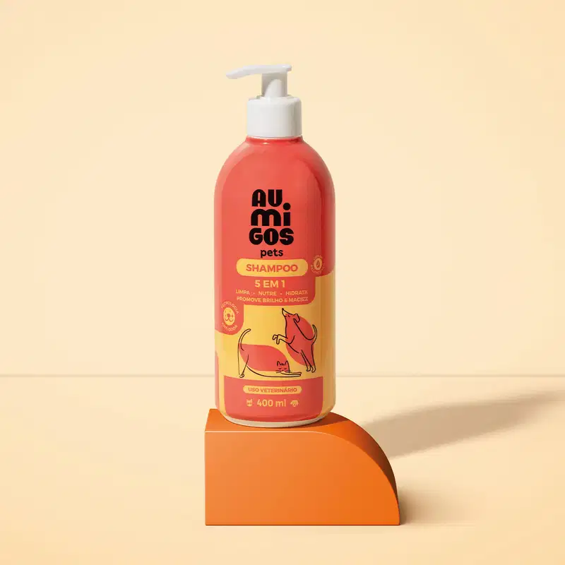 Frasco laranja e rosa com ilustração de pets no rótulo e bomba dosasdora branca contendo shampoo 5 em 1 da marca Au.Migos Pets está em uma plataforma laranja com fundo e superfície na mesma cor.