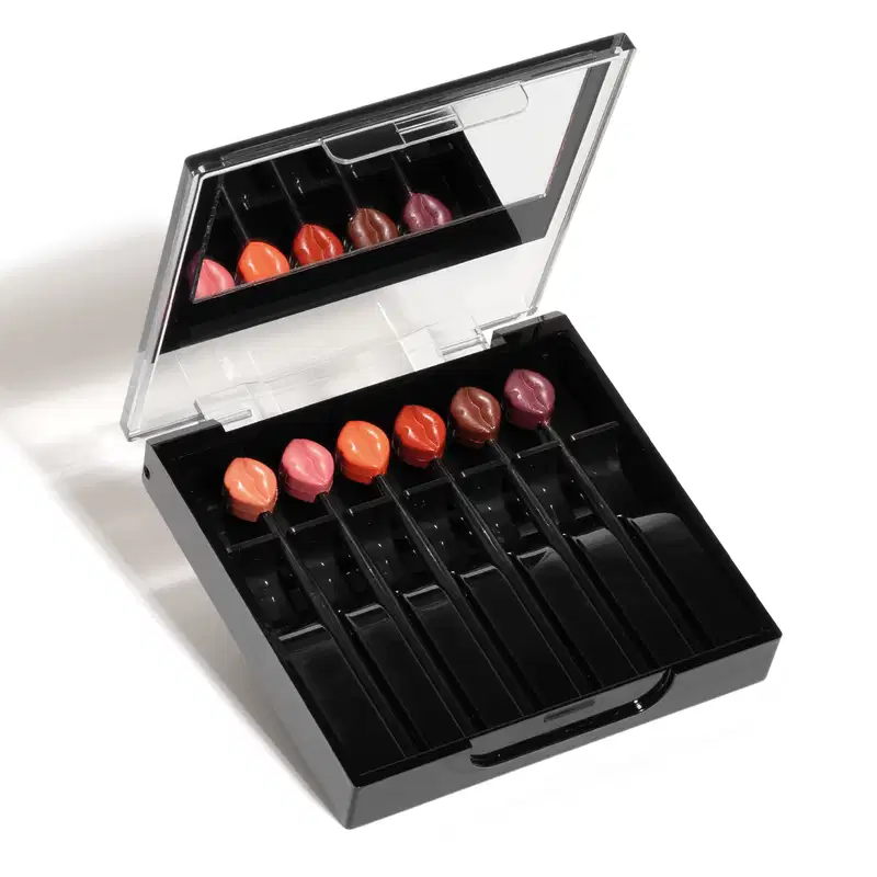 Estojo preto com seis mini batons de diferentes tonalidades de rosa e vermelho com espelho na tampa da marca Make B. Six Mini Lips.