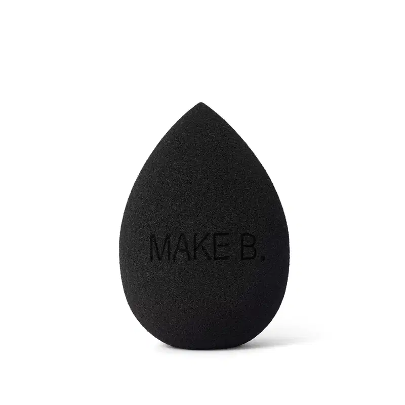Esponja de maquiagem Make B. Super Blend preta em formato de gota. A esponja é feita de material macio e poroso destinada à aplicação de maquiagem.