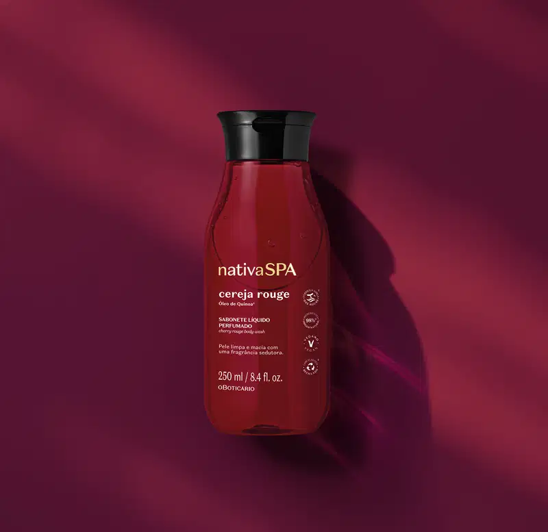 Frasco transparente com liquido vermelho escuro, tampa preta e rótulo em letras brancas e douradas contendo 250ml de sabonete líquido da arca Nativa SPA Cereja Rouge em fundo vermelho escuro.