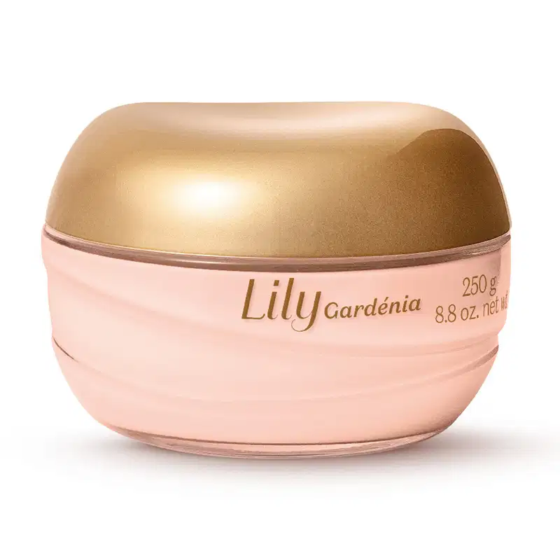 Creme acetinado corporal Lily Gardénia. Embalagem em formato de pote redondo com tampa dourada brilhante. Corpo do pote na cor rosa claro. Rótulo na parte inferior com o nome do produto "Lily Gardénia". Aparência elegante e sofisticada.
