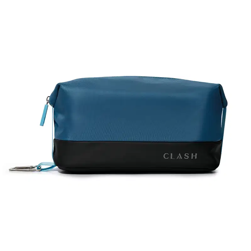 Bolsa de cosméticos azul-marinho com faixa preta na barra, com zíper e alça, exibindo a marca "CLASH" em letras grandes no canto inferior direito.