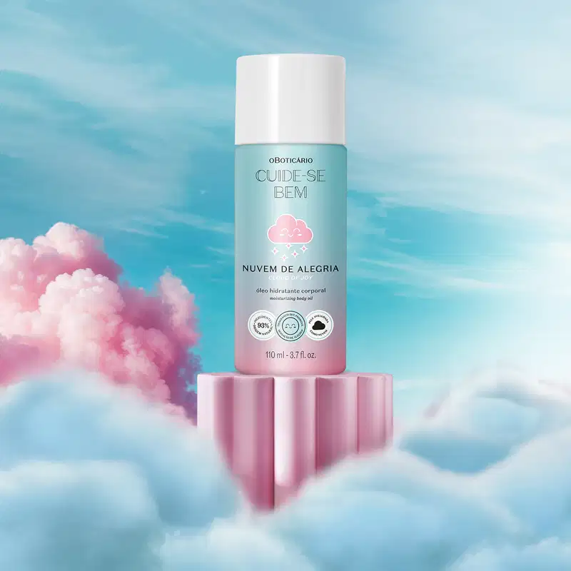 Frasco em tons de rosa e azul com ilustração de uma nuvem sorridente e tampa branca contendo óleo hidratante corporal Cuide-se Bem Nuvem de Alegria em cenário com nuvens coloridas e céu azul com nuvens brancas.