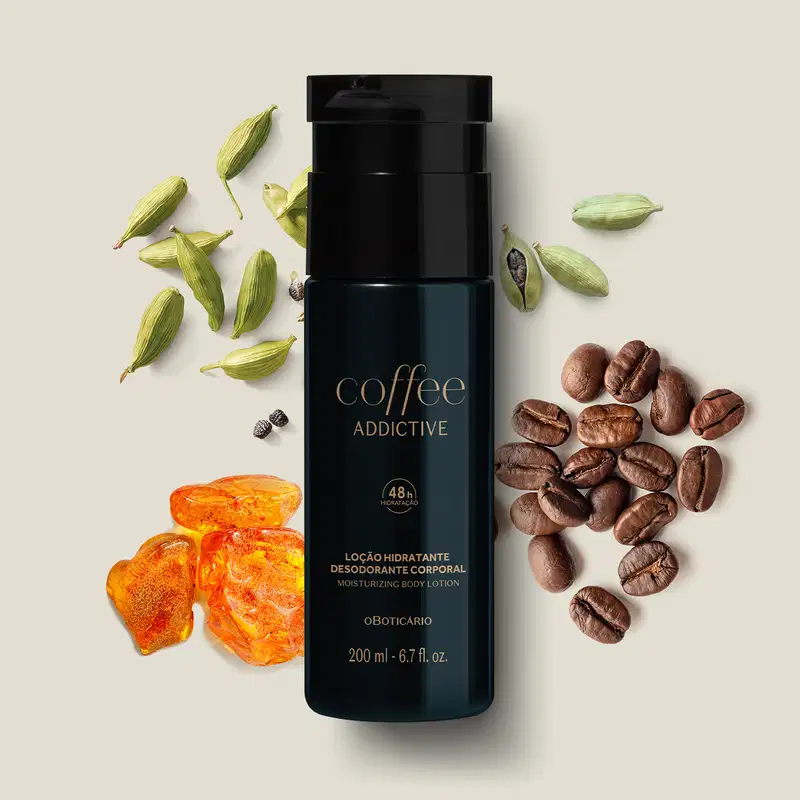 Frasco preto com letras bege escuro de loção hidratante desodorante corporal Coffee Addictive Oriental Aromático rodeado por grãos de café, flores e fatias de laranja em superfície bege clara.