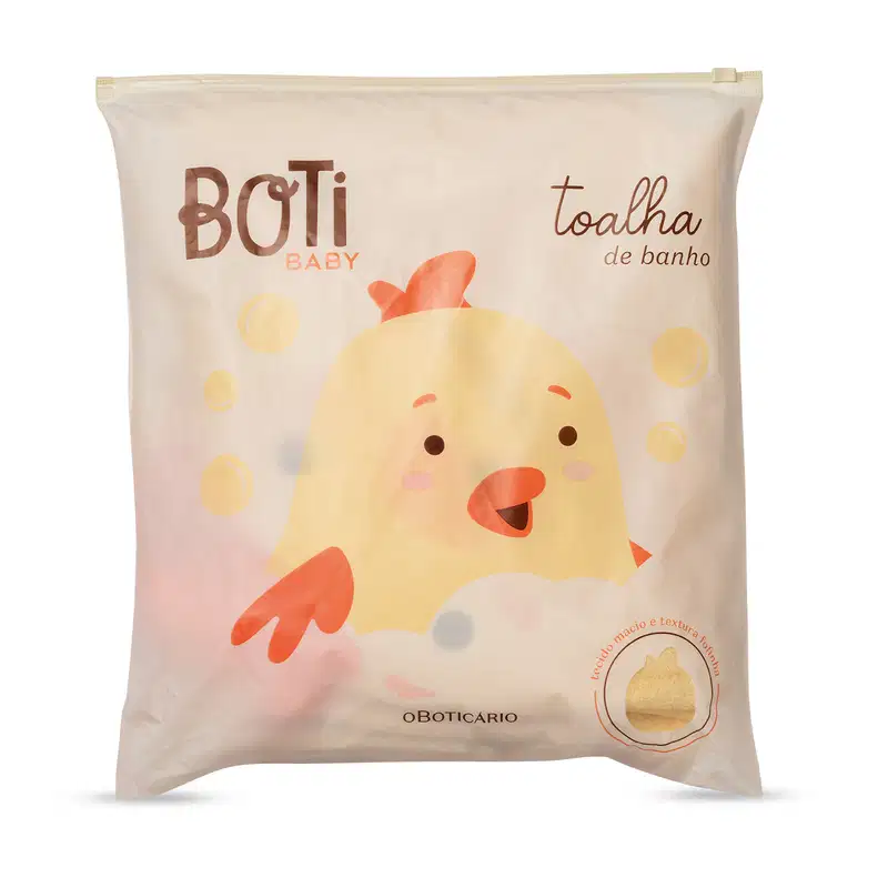 Embalagem de toalha de banho da linha Boti Baby, com ilustração de um pintinho amarelo e texto em marrom e laranja. Produto com textura e maciez indicadas na embalagem.