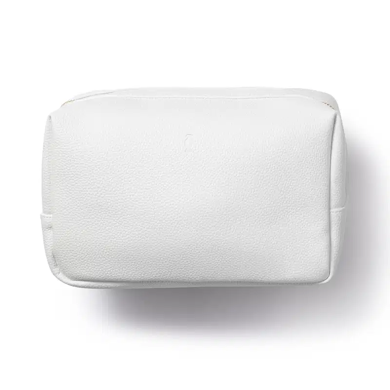 O produto apresentado na imagem é uma bolsa cosmética branca. Trata-se de uma embalagem retangular com zíper, feita de material liso e texturizado. Não há rótulos ou marcas visíveis na superfície da bolsa.