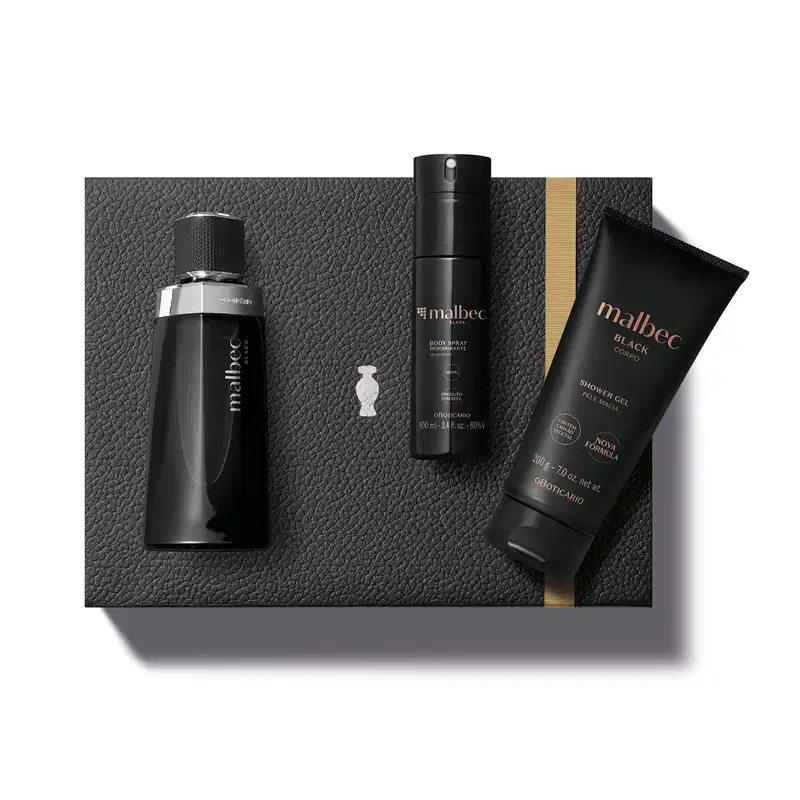 Caixa preta com fita dourada e detalhe prateado e três produtos Malbec: frasco preto com detalhes e letras prateadas de desodorante colônia, bisnaga preta com letras douradas de shower gel e embalagem preta com letras douradas de body spray.
