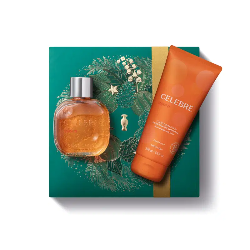Imagem do Kit Presente Natal Celebre Agora com um vidro redondo com líquido laranja e tampa dourada de desodorante colônia e uma bisnaga laranja de loção hidratante corporal sobre uma caixa verde presenteável com estampa natalina.
