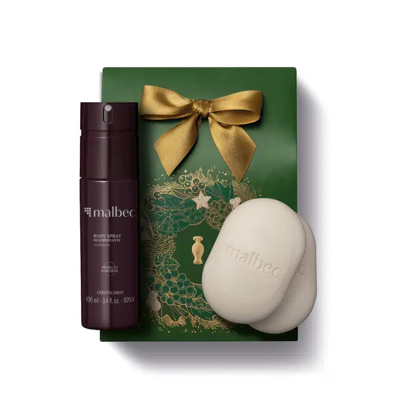 Imagem do Kit Presente Natal Malbec Cuidados com frasco vinho e cinza de body spray e dois sabonetes em barra brancos sobre uma sacola presenteável verde com estampa natalina.