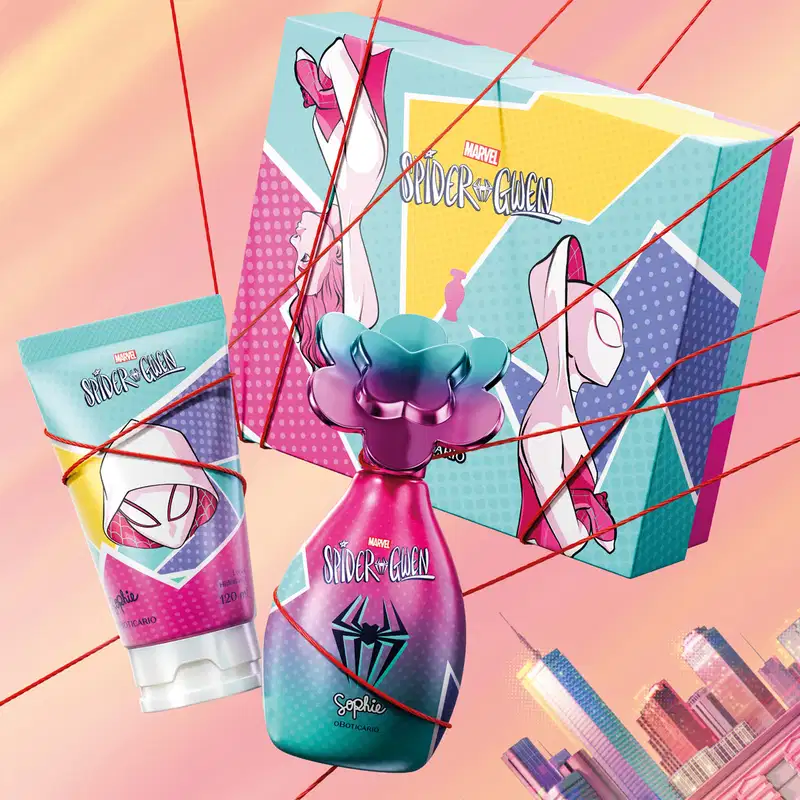 Frasco de colônia infantil, bisnaga de creme corporal e caixa presenteável da marca Sophie Marvel Spider-Gwen em tons de rosa, azul, violeta e amarelo, com flores e elementos gráficos presos por linhas vermelhas sobre fundo rosa com o skyline urbano.