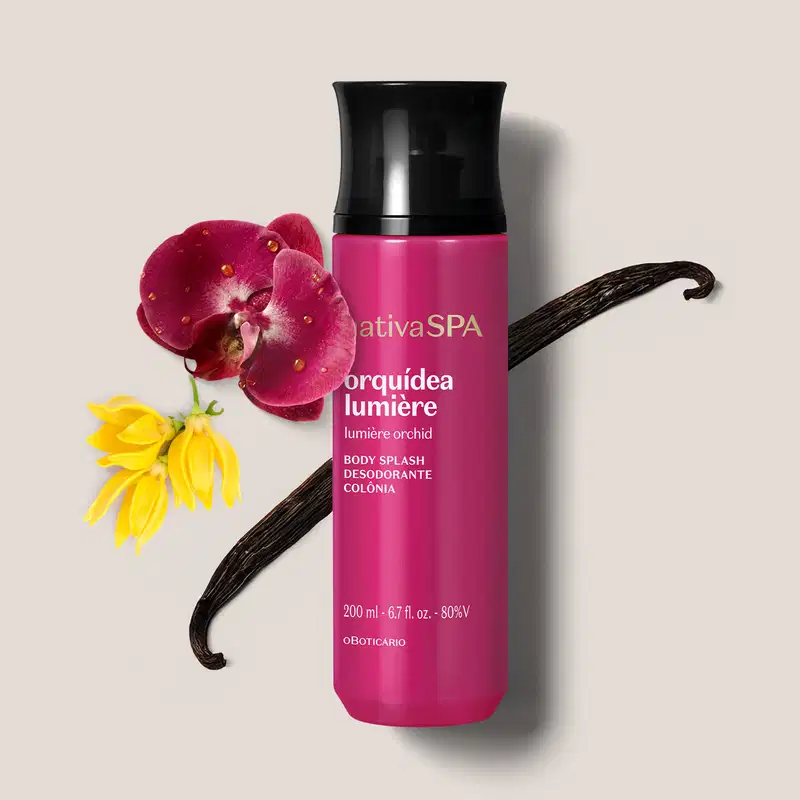 Frasco cilíndrico de item de perfumaria da marca Nativa SPA Orquídea Lumière, na cor rosa vibrante, com tampa preta cercado por uma orquídea rosa, outra amarela e uma fava de baunilha sobre superfície branca.