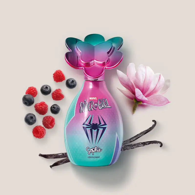Frasco de colônia infantil da marca Sophie em parceria com Marvel Spider-Gwen, cercada por frutas vermelhas, favas de baunilha e uma flor rosa sobre fundo claro.