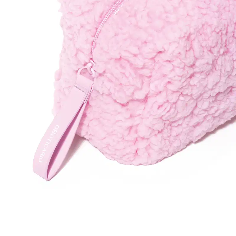 Imagem de um nécessaire rosa felpudo em formato retangular com zíper e alça para transporte.