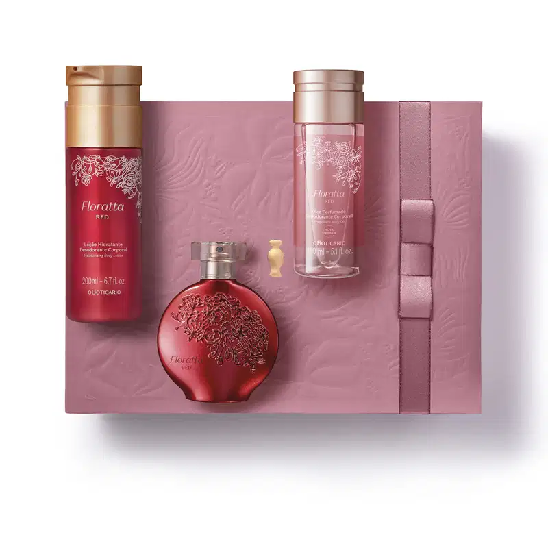 Caixa de presente rosa, nécessaire branco e três produtos da marca Floratta Red, sendo um frasco de óleo perfumado corporal, vidro de desodorante colônia e embalagem de loção hidratante corporal, todos em cor vermelha com detalhes dourados.