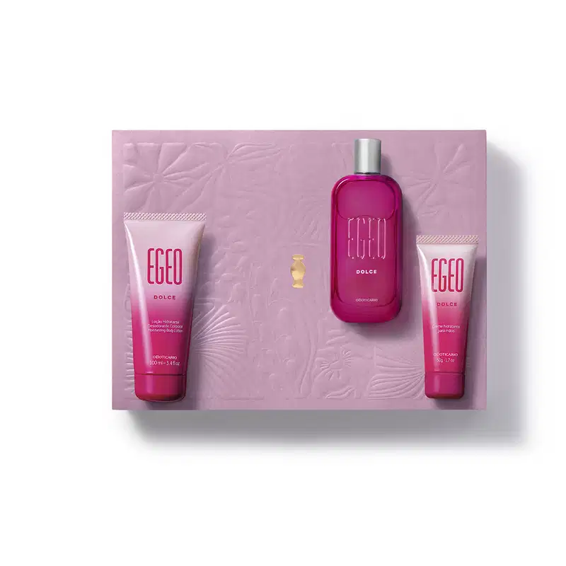 Caixa rosa com flores em relevo e três itens da marca Egeo Dolce, sendo uma bisnaga de creme hidratante para as mãos, outra de loção hidratante corporal e um vidro com tampa prateada contendo desodorante colônia.