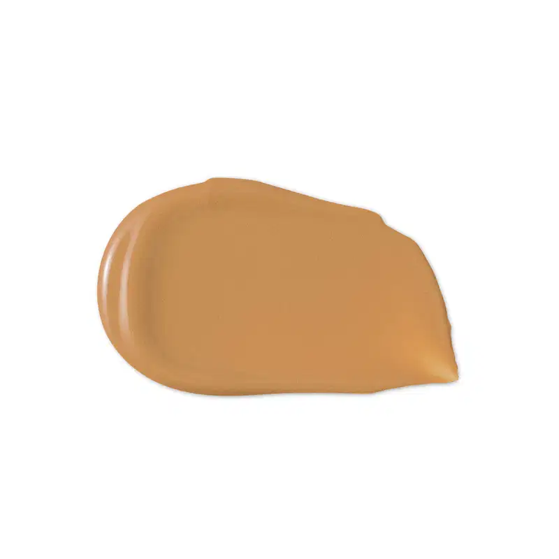 O produto de beleza apresenta uma textura cremosa, de cor alaranjada, com aparência suave e brilhante, indicando uma consistência macia e deslizante.