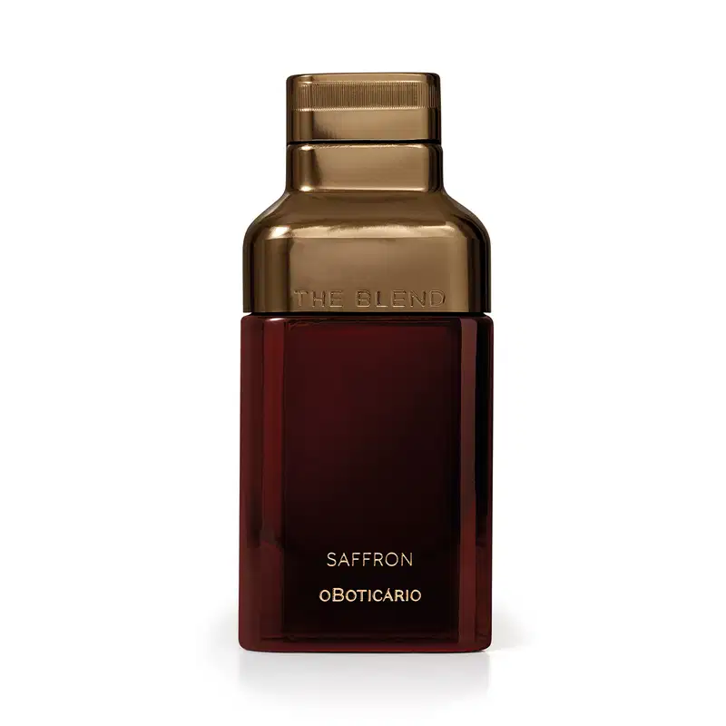 Frasco dourado com rótulo vermelho escuro, contendo o texto "The Blend" e "Saffron oBoticario". O produto possui uma embalagem elegante e sofisticada, com destaque para o tom dourado predominante.