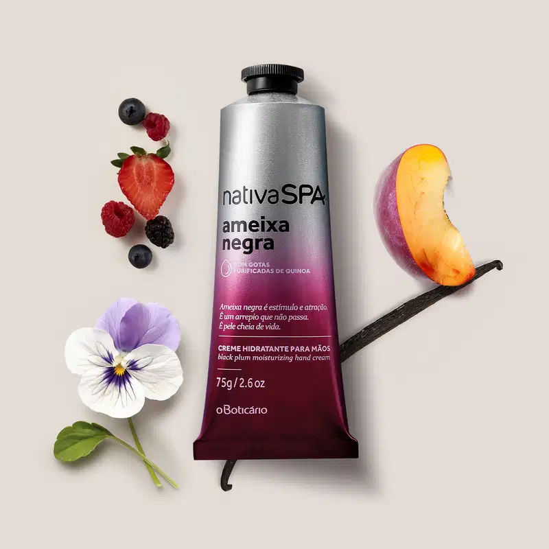 Tubo de creme hidratante para mãos da marca Nativa SPA da linha Ameixa Negra, com rótulo degradê do roxo ao prata, em meio a frutas vermelhas, flores, uma fava de baunilha e uma fatia de ameixa, sobre fundo claro.