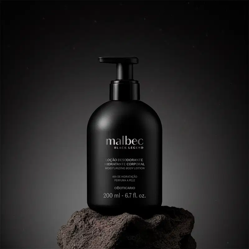 Recipiente preto de item de perfumaria da marca Malbec Black Legend, com bomba doseadora, sobre superfície escura e texturizada. Embalagem simples e minimalista, com informações do produto em destaque.