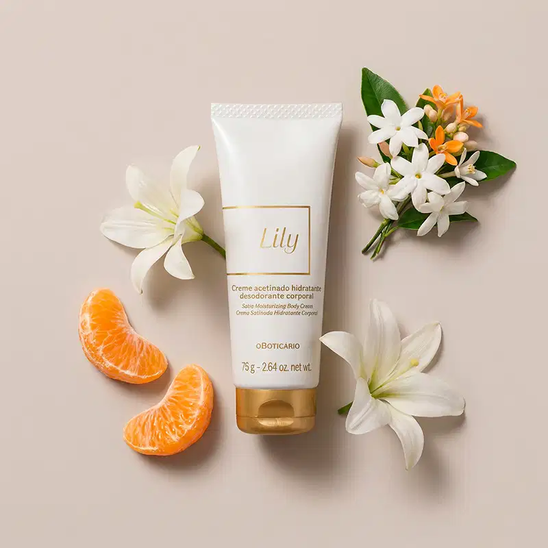 Imagem do tubo branco com rótulo dourado da marca Lily, cercado por flores brancas e laranjas, fatias de laranja e folhas verdes sobre fundo bege claro.
