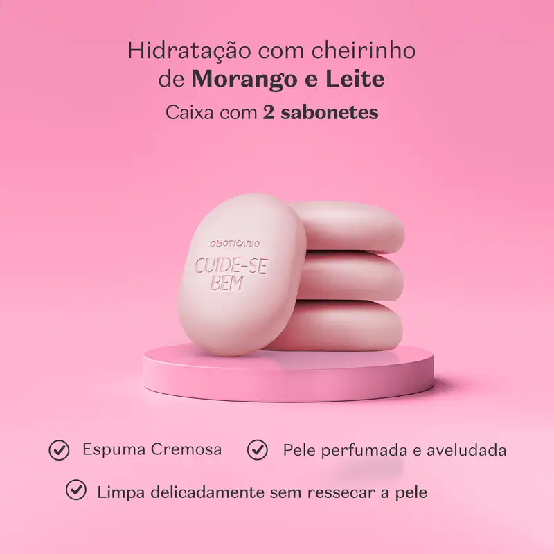 Imagem de quatro sabonetes em barra rosa da marca Cuide-se Bem Morango e Leite em superfície e fundo rosa, com letras pretas informando os benefícios e as características do produto.