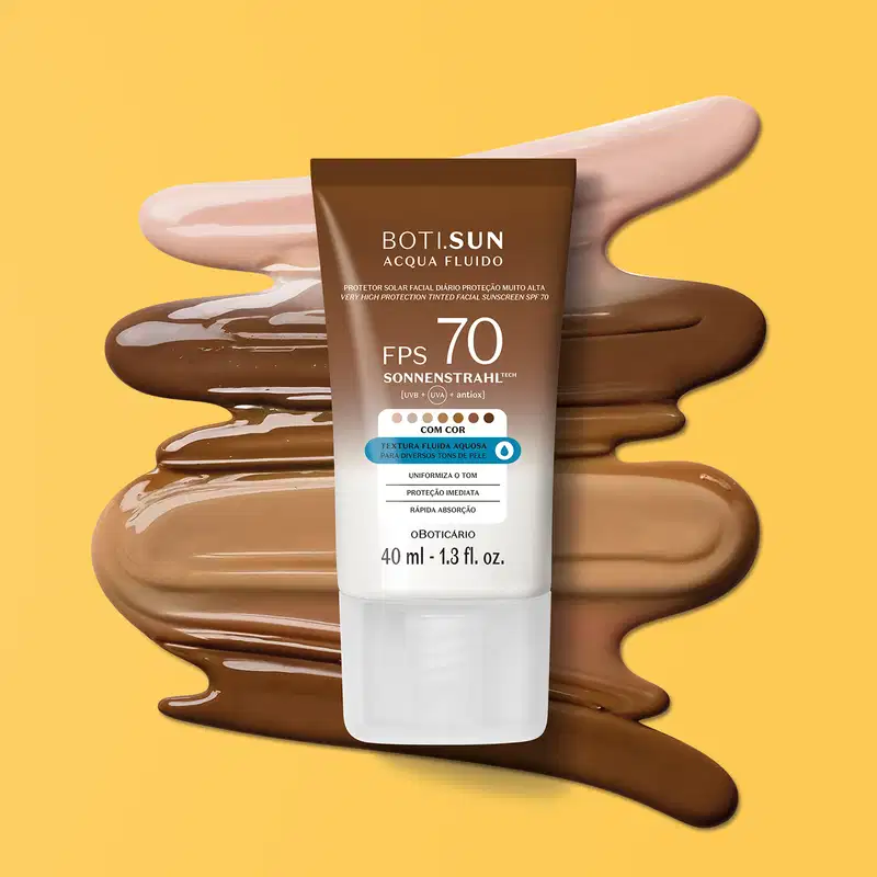 Bisnaga de protetor solar facial fluido com cor da marca Boti Sun com FPS 70, nas cores branca e marrom e um pouco de produto de diferentes tonalidades espalhado por trás da embalagem e fundo amarelo.