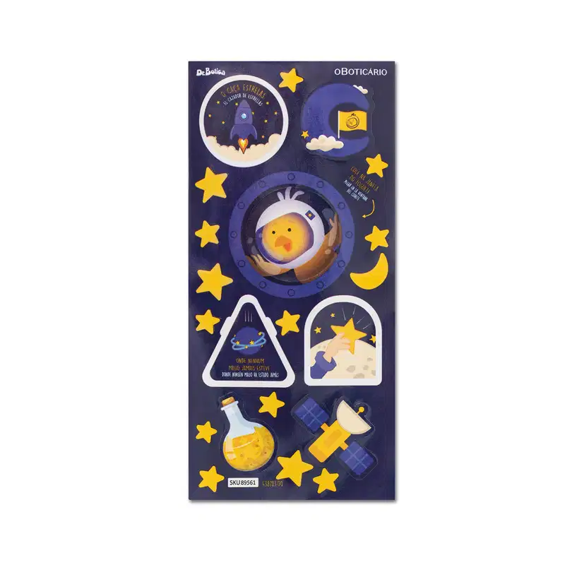 Embalagem com ilustrações de foguete, estrelas, lua e satélite em fundo azul escuro, com texto "Dr Botica" e "O Boticario" visíveis.