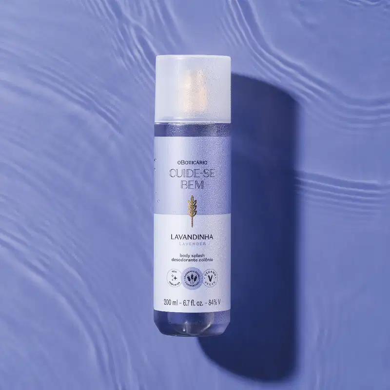 Frasco branco de item de perfumaria da marca Cuide-se bem, com rótulo roxo e dourado, sobre superfície azul com reflexos ondulados.