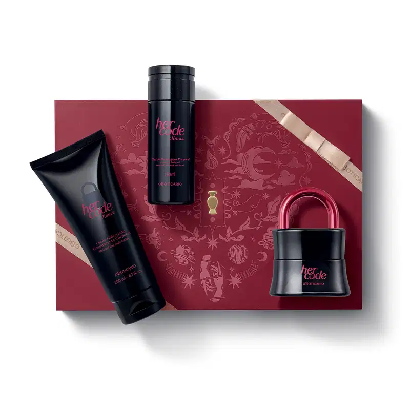 Caixa vermelha com detalhes dourados e fita dourada fina. Sobre ela, três itens de perfumaria da marca Her Code Climax, sendo um desodorante colônia preto com tampa em formato de cadeado, um body spray preto e uma bisnaga preta de loção corporal.