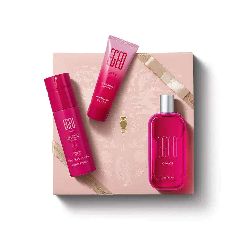 Caixa rosa claro com padrão floral em dourado e três itens de perfumaria da marca Egeo Dolce sobre ela, sendo: frasco de desodorante colônia, tubo de body spray e bisnaga de creme hidratante desodorante, todos na cor pink.