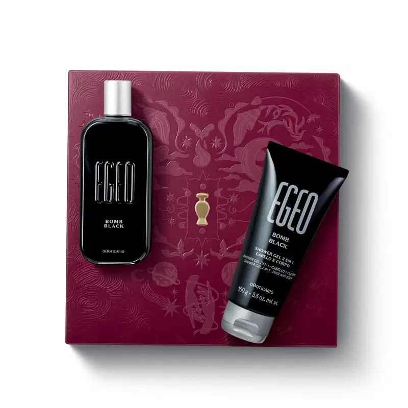 Caixa de presente de cor vinho com um grande coração ilustrado detalhes de temática celestial. Sobre ela, itens de perfumaria da marca Egeo Bomb Black, sendo um frasco de desodorante colônia preto e bisnaga de gel de banho preta, ambas com tampa prateada.