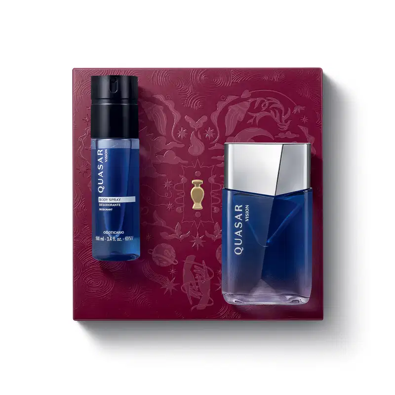 Caixa de presente vinho com coração ilustrado detalhes de temática celestial. Sobreposta a ela, itens de perfumaria Quasar Vision, sendo um frasco de desodorante colônia azul com design angulado e um body spray cilíndrico azul com tampa borrifadora escura