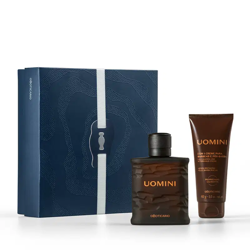 Caixa azul-marinho com padrão ondulado, contendo frasco de item de perfumaria da marca Uomini e tubo de creme pós-barba da mesma marca, em embalagens com cores predominantes preta e marrom.
