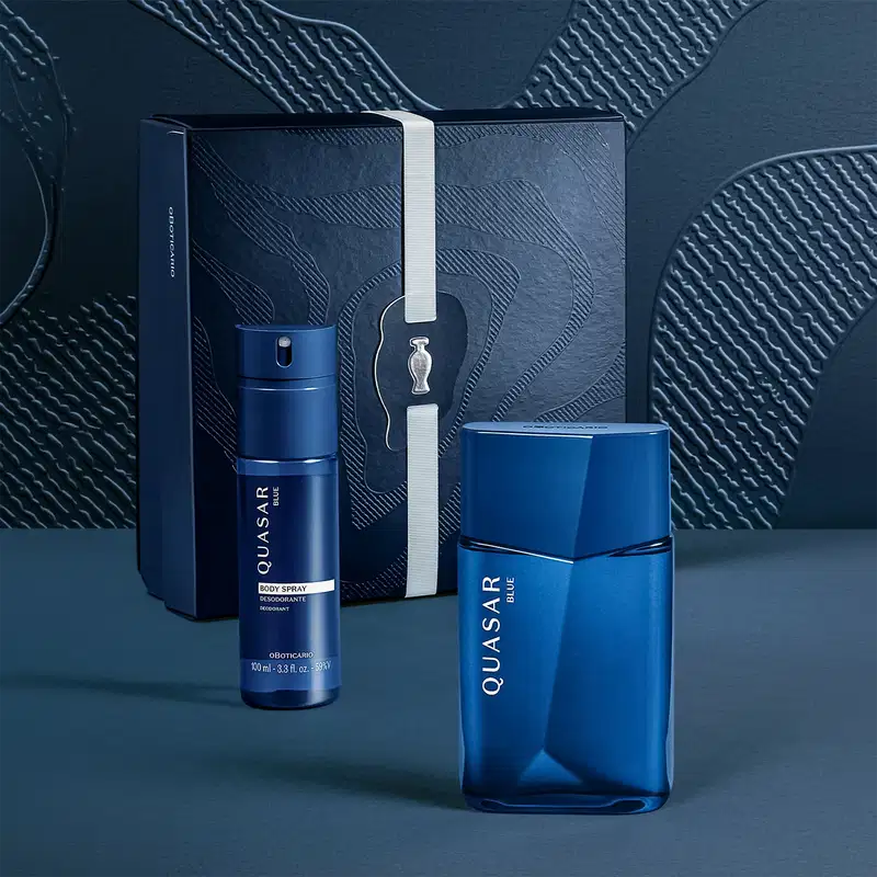Caixa preta com detalhes em azul contendo um frasco de spray corporal azul e um frasco de item de perfumaria azul da marca Quasar.