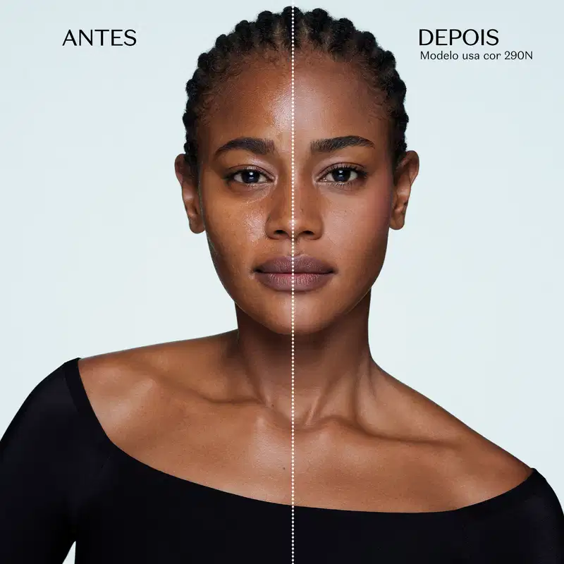 Retrato frontal de uma mulher negra com penteado trançado, olhar sério e expressão neutra, usando camiseta gola canoa preta, em fundo branco com divisão vertical  na metade do rosto e os dizeres  "antes" e "depois", mostrando o efeito da aplicação da base