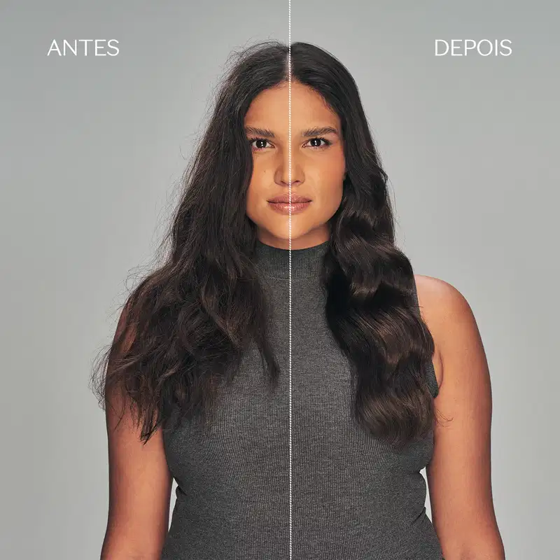 Antes e depois da transformação de cabelos. A imagem mostra uma mulher com cabelos longos e ondulados, usando um suéter cinza. A metade da esquerda mostra seus cabelos antes do tratamento, enquanto a da direita mostra o resultado após o tratamento.