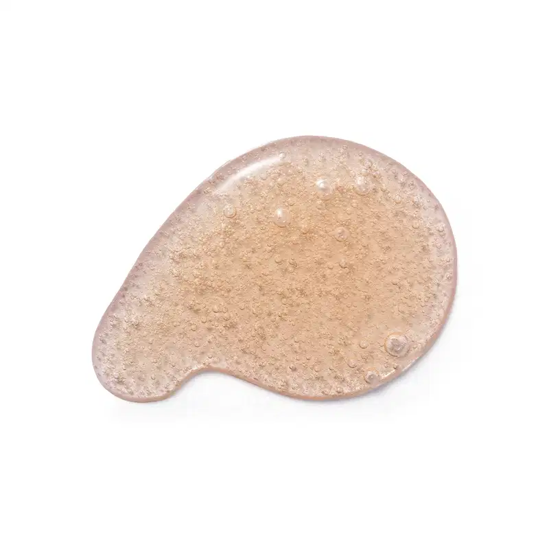 Textura do sabonete líquido Cuide-se Bem Deleite Caramelizado com aspecto granulado, brilhante e úmido, com pequenas bolhas distribuídas uniformemente sobre uma superfície clara.