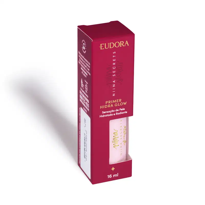 Embalagem retangular de papelão na cor vinho, com detalhes dourados contendo o frasco do Primer. Pequeno frasco rosa translúcido embutido na caixa. Volume de 16ml indicado na embalagem.