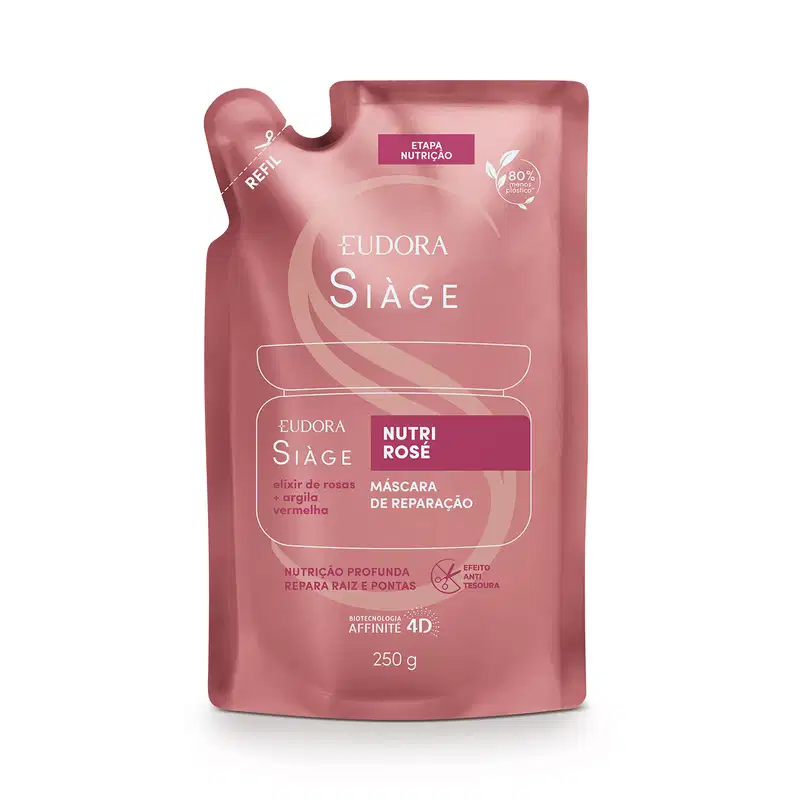 Embalagem flexível como um pacote de plástico rosé com detalhes em vermelho claro e branco e indicação de lugar para cortar com tesoura. No centro, um desenho da silhueta do pote original contém as informações do rótulo do refil em letras brancas.