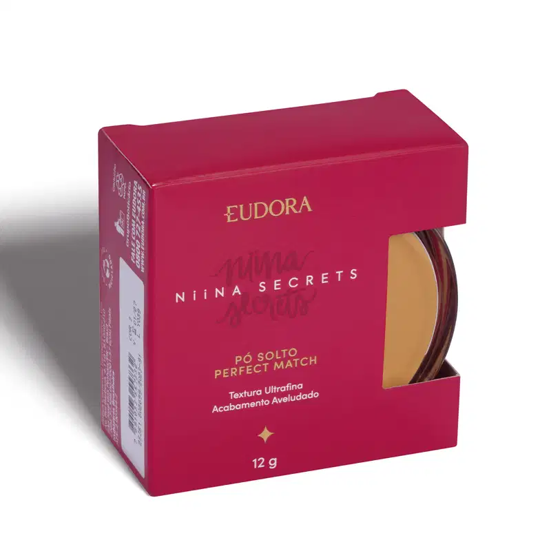A imagem mostra o produto dentro de uma caixinha vermelha, com lateral semi-aberta, que dá pra ver uma parte do produto. A caixa tem logo da marca e linha escrito com letras douradas e branca.